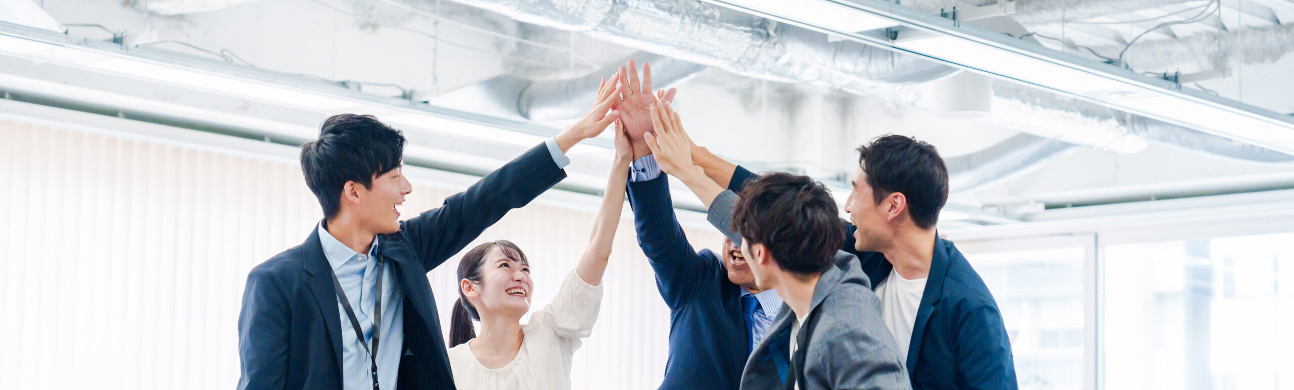 business people giving high fives at the office