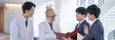 a male doctor and a medical information representative mr talk with smiles at the hospital.