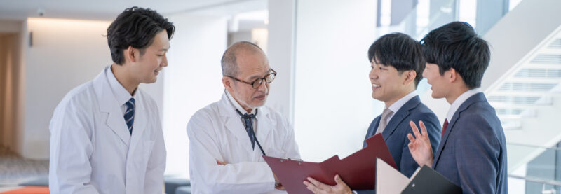 a male doctor and a medical information representative mr talk with smiles at the hospital.