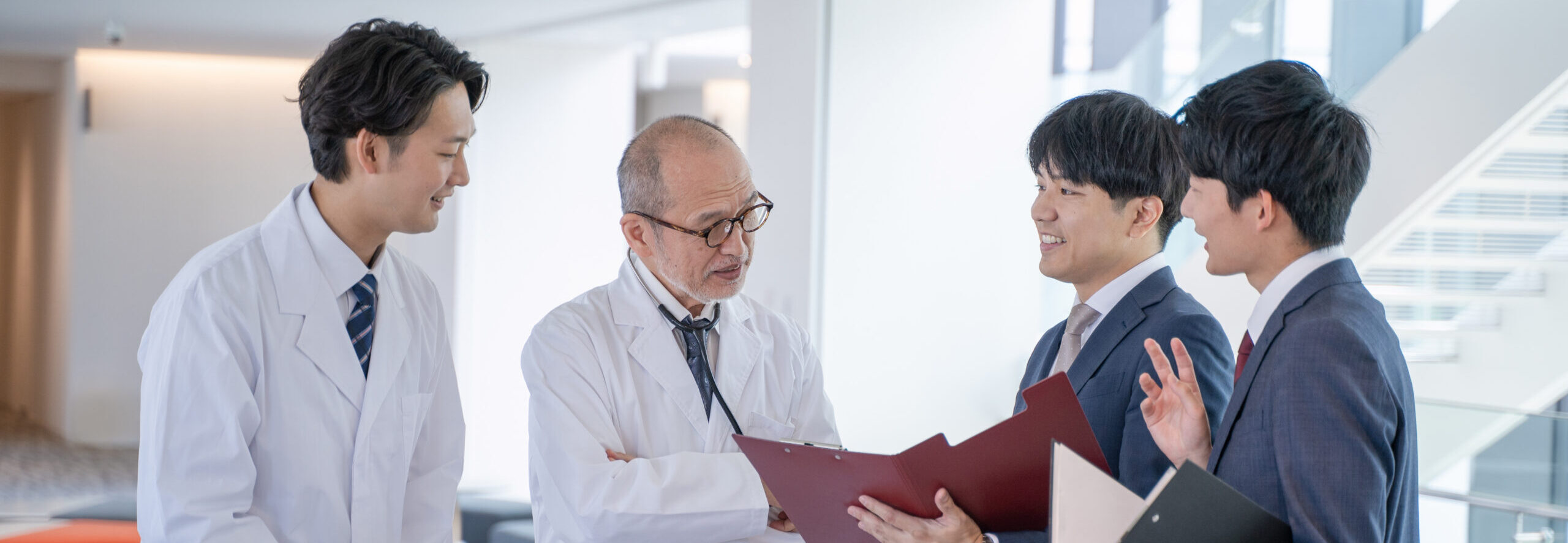 a male doctor and a medical information representative mr talk with smiles at the hospital.