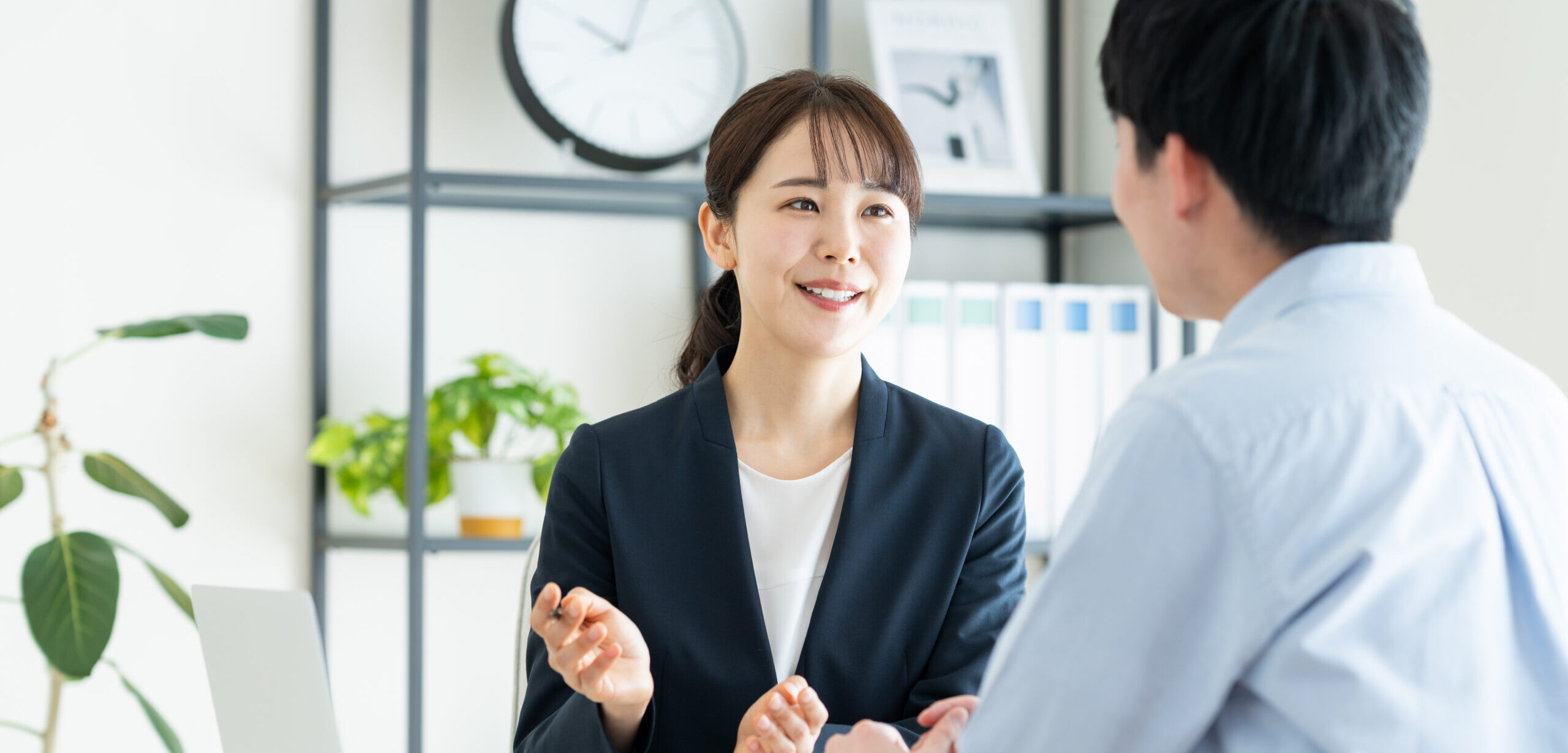 female consultant explaining to young man in office